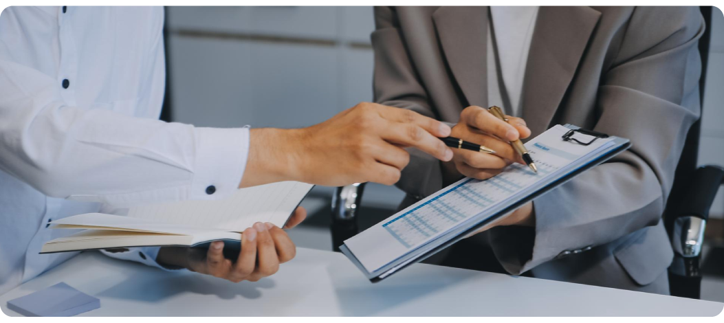 Foto de personas señalanzo un calendario con bolígrafos